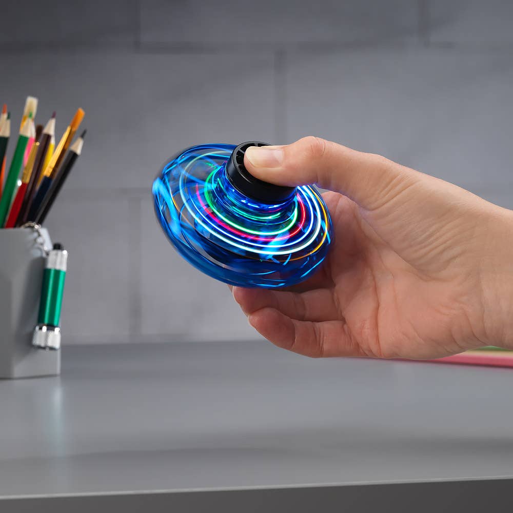 Hand holding a glowing blue vortex spinner top with black center cap