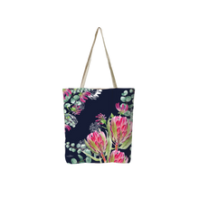 Navy reusable tote bag with pink tropical flowers and green foliage, long canvas handles