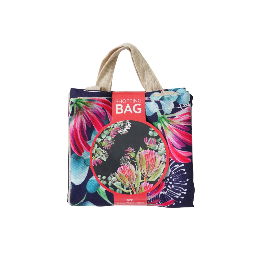 Navy shopping tote with pink flower print, short handles, red product label on front