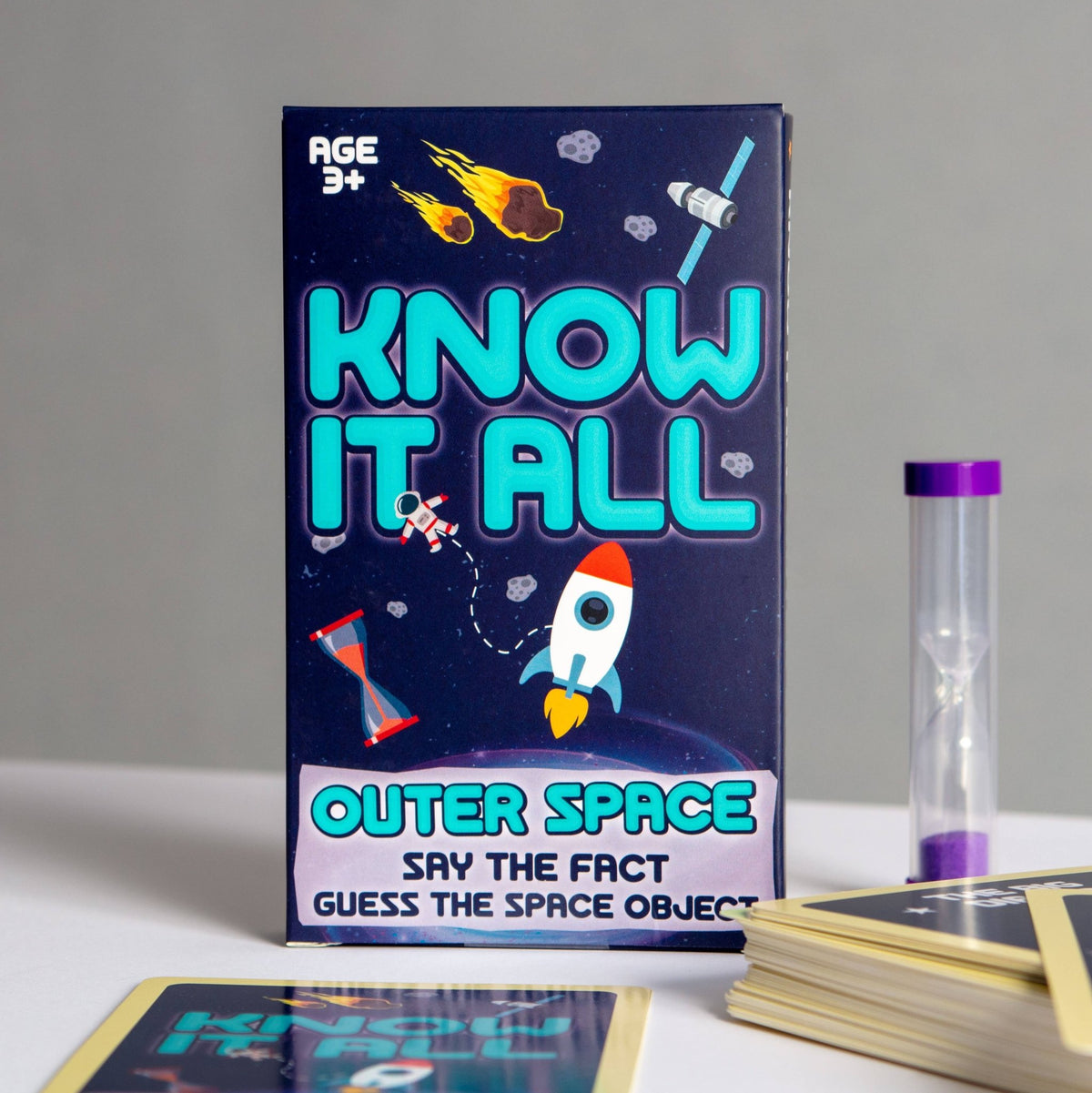 Outer space card game box with 'Know It All' lettering and rocket illustration, plus tube