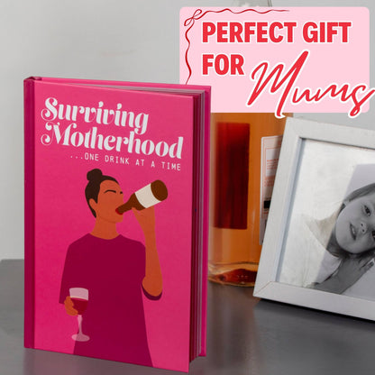 Surviving Motherhood gift book with pink cover next to a gray portrait photo frame
